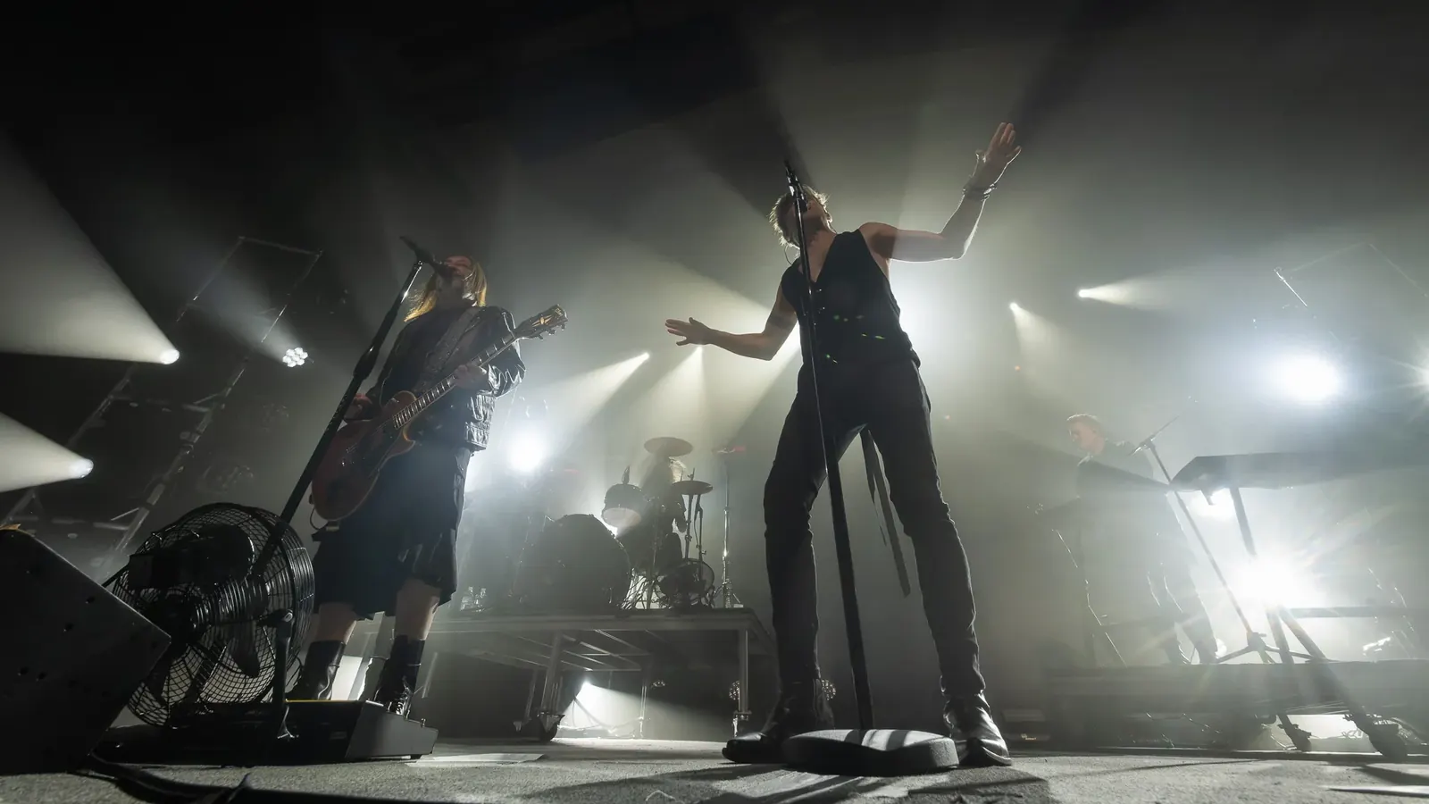 Band performing under white stage lights