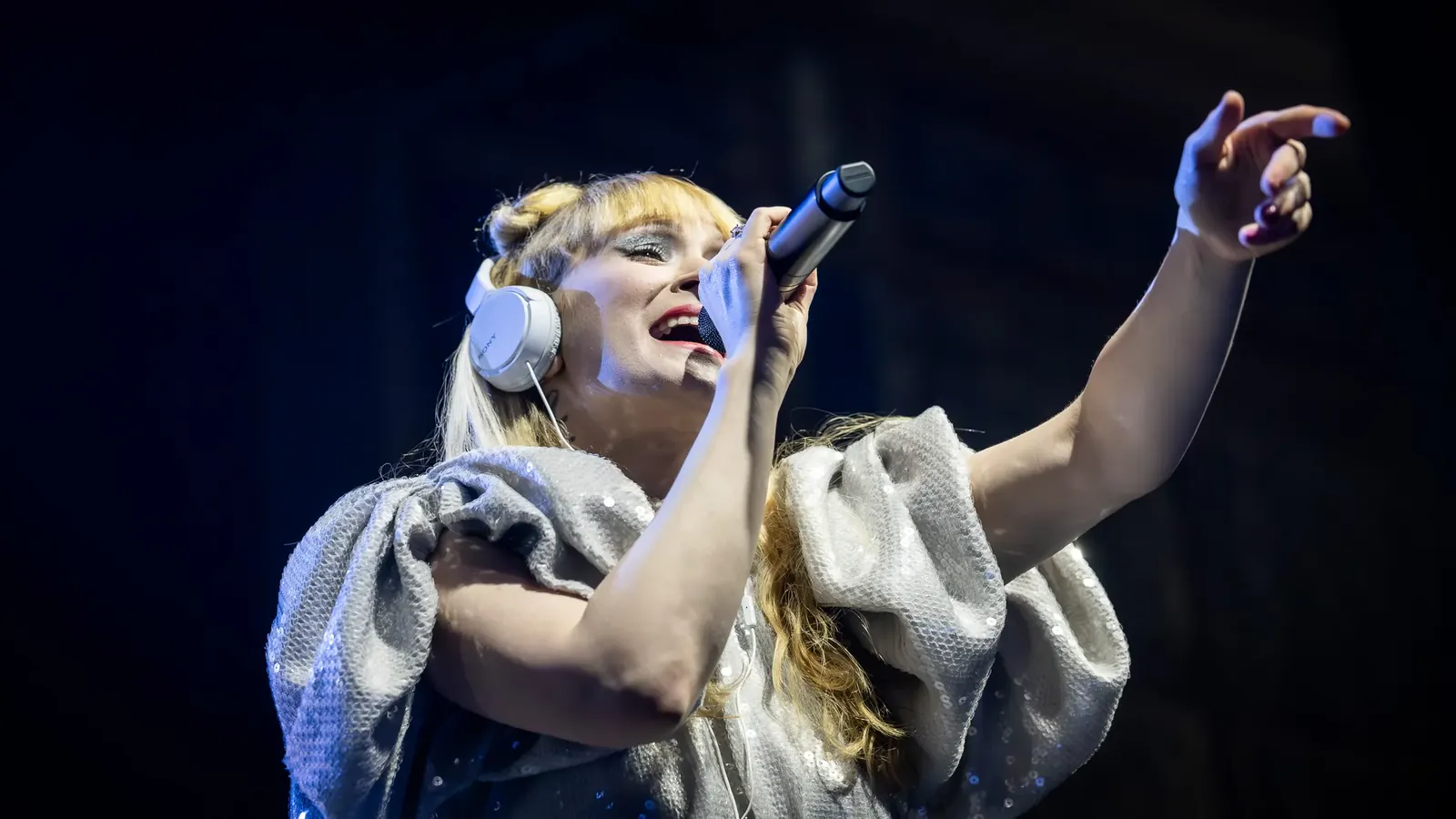 Vocalist performing with an outstretched arm
