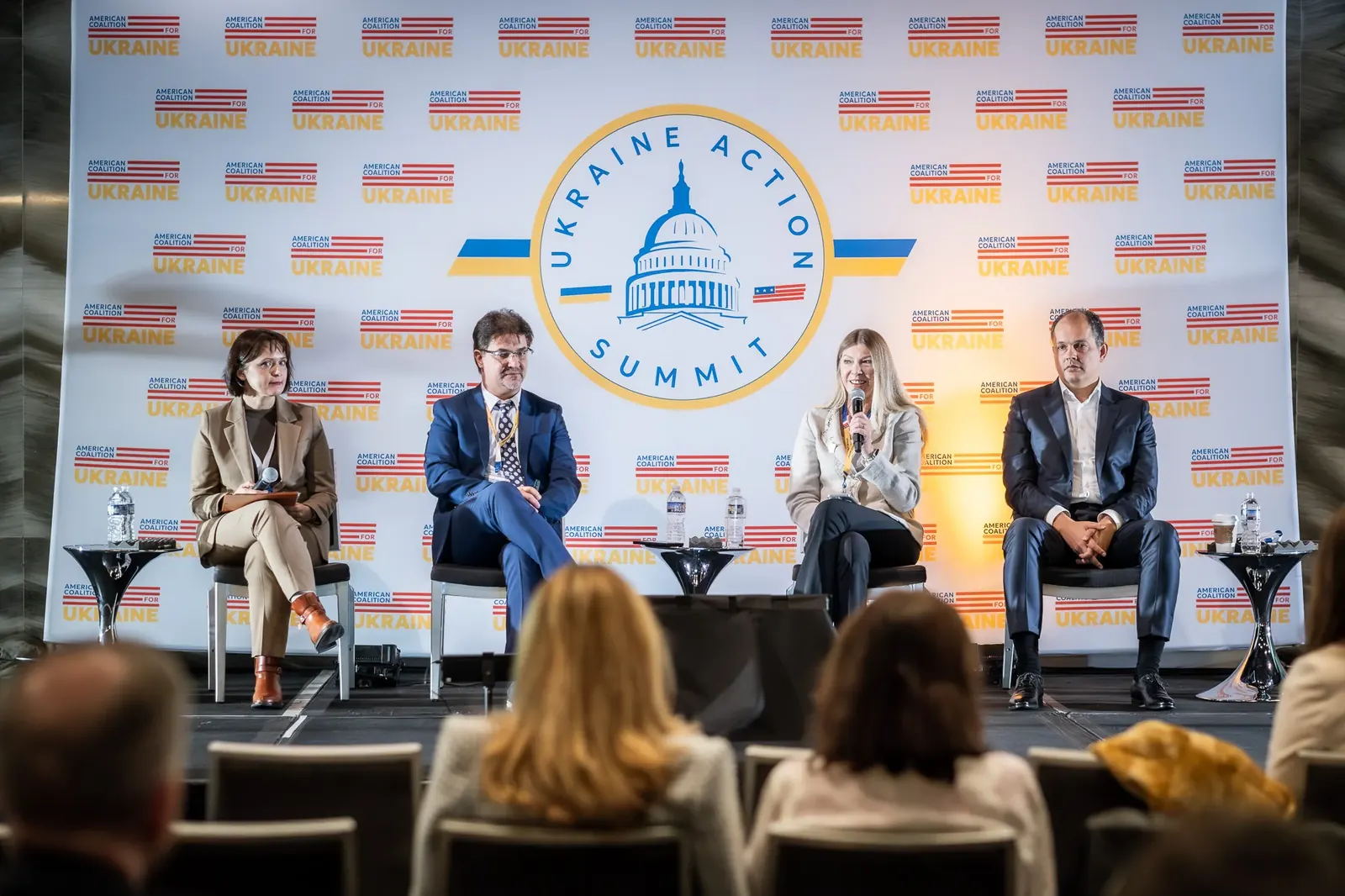 Conference panel with the event backdrop and audience